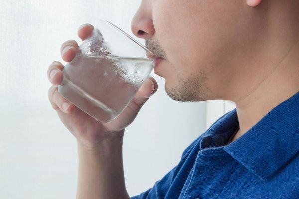 Seorang pria sedang minum air.